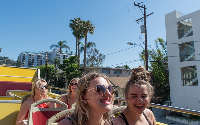 Tourists enjoying a sunny day on a Los Angeles hop-on hop-off bus tour.