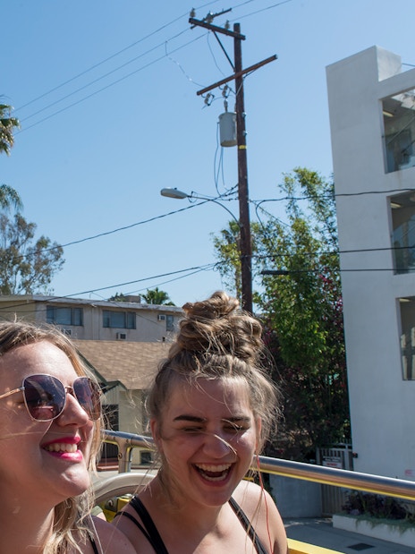 Tourists enjoying a sunny day on a Los Angeles hop-on hop-off bus tour.