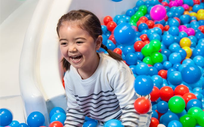 Child playing in a colorful ball pit at Macau Kids City.