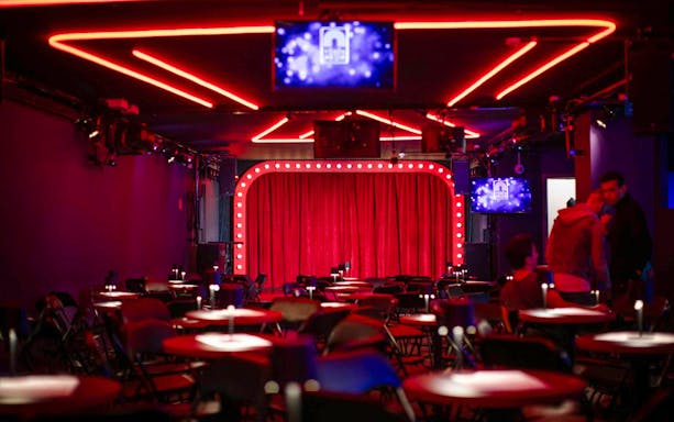 Venue setup with red curtains and neon lights for Drag Queen Hungary Show.