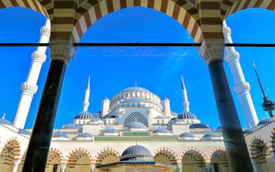 Blue Mosque in Istanbul framed by arches and minarets against a clear blue sky.