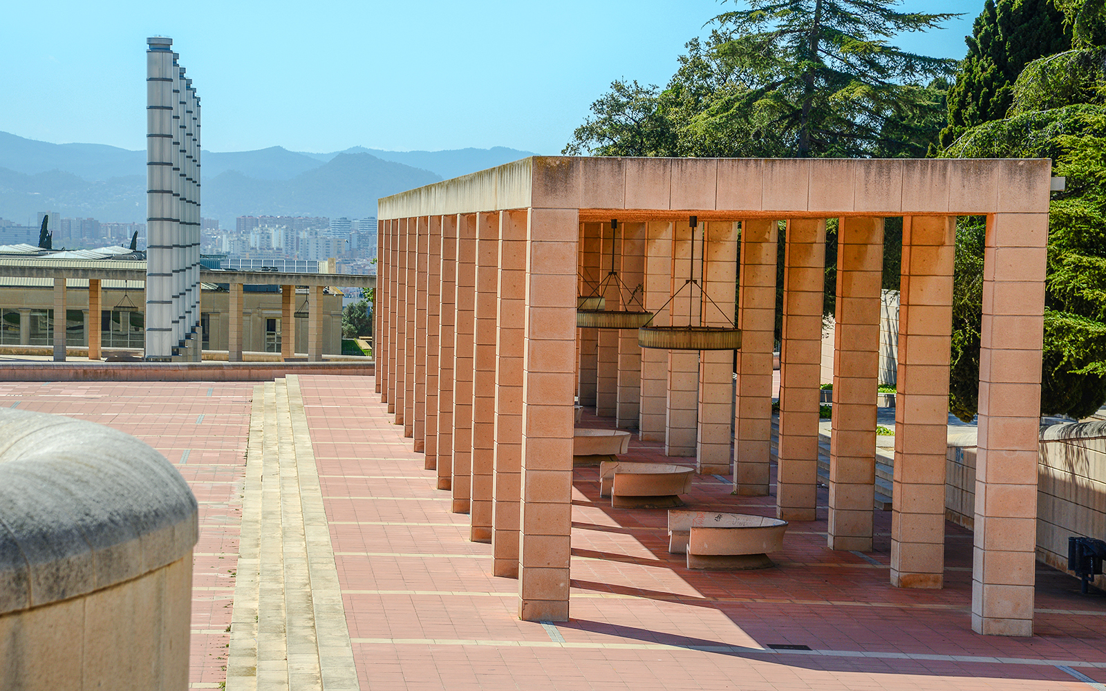 Montjuic Olympic Ring colonnade with cityscape and mountains in the background, Barcelona.