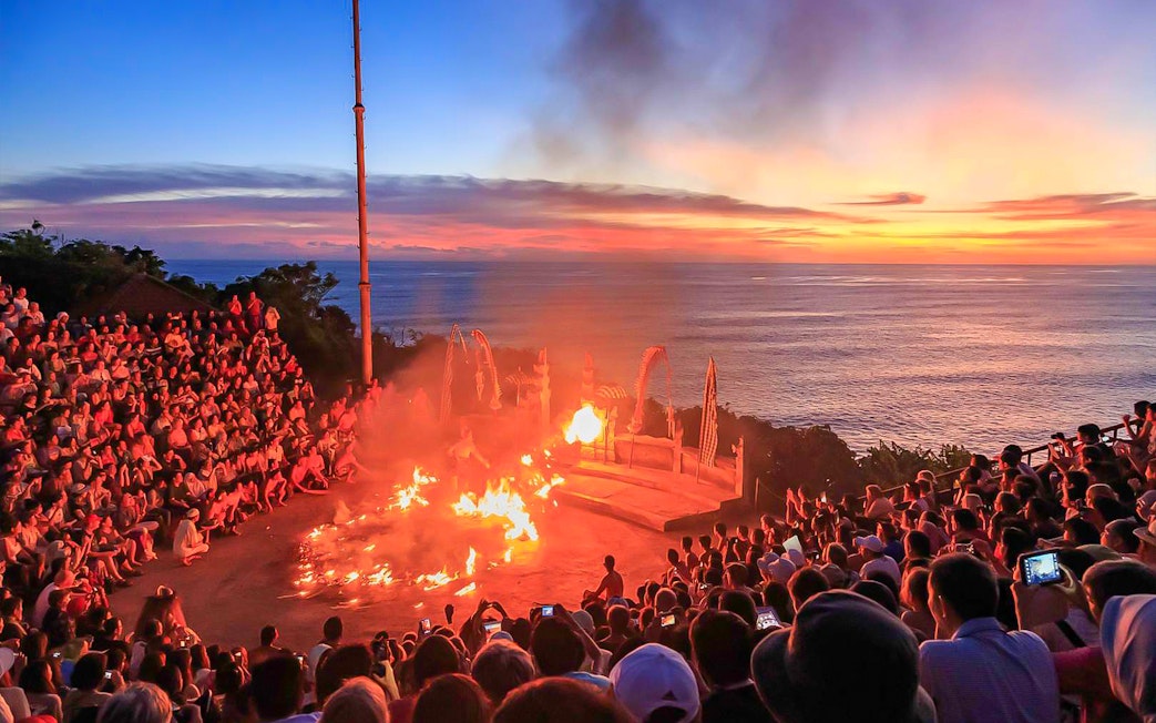 Sunset Kecak dance performance at Uluwatu Temple, Bali, with ocean view.