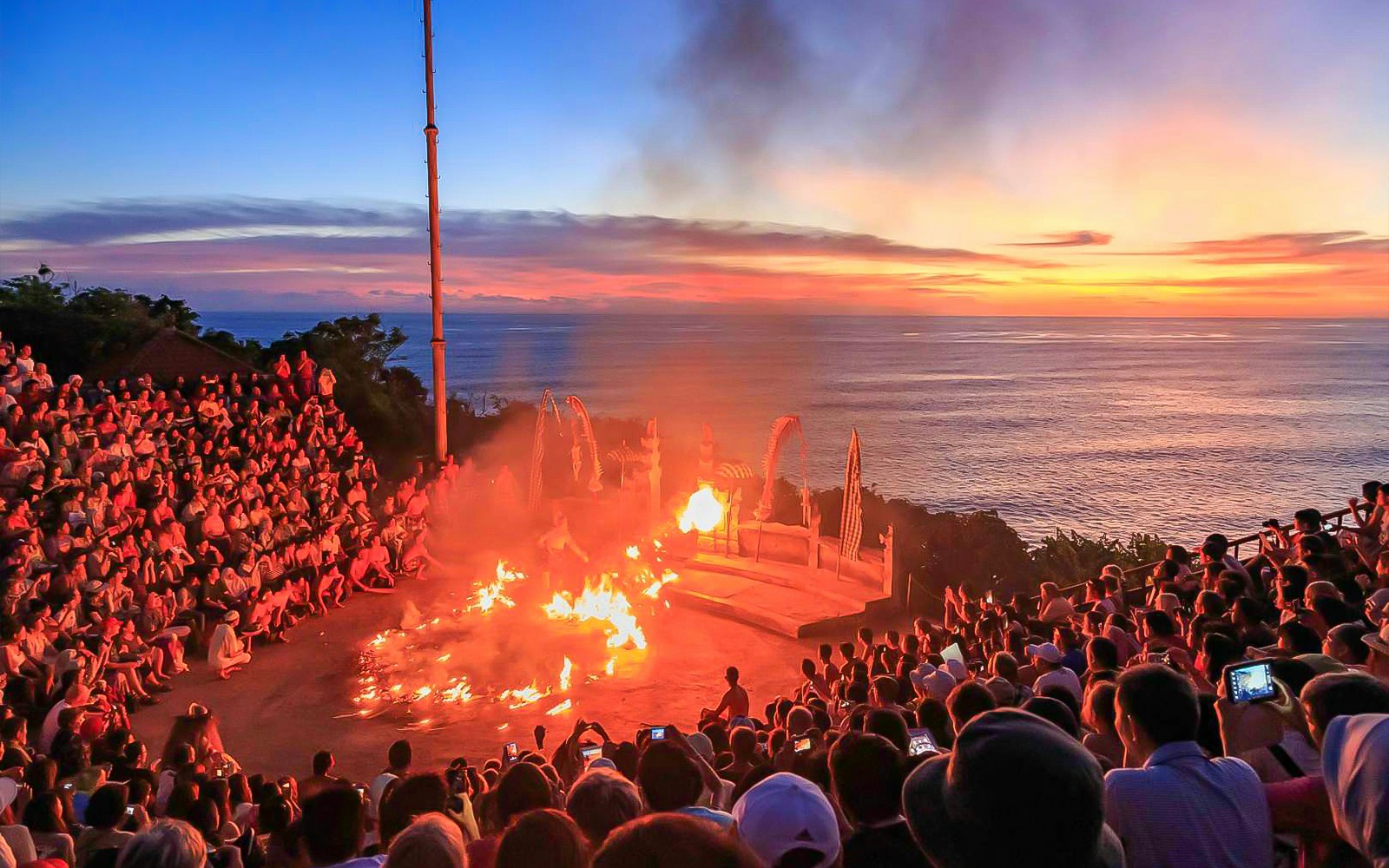 Sunset Kecak dance performance at Uluwatu Temple, Bali, with ocean view.