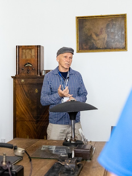 Tour guide explaining historical artifacts at Oskar Schindler's desk in Schindler's Factory, Krakow.