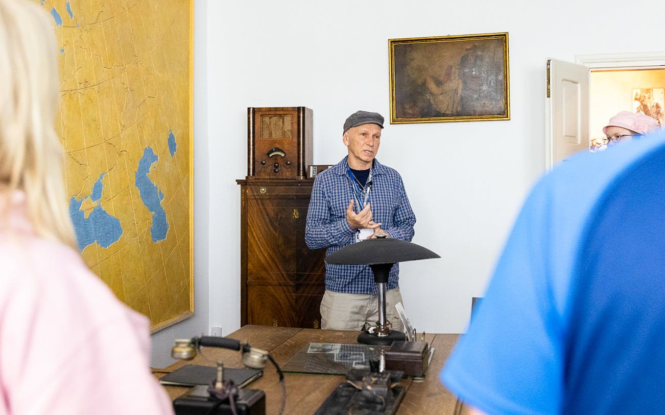 Tour guide explaining historical artifacts at Oskar Schindler's desk in Schindler's Factory, Krakow.