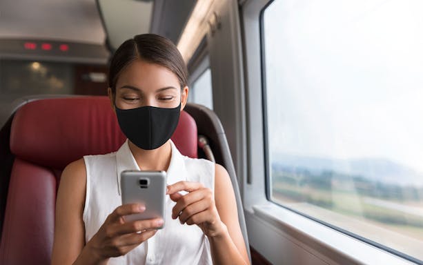 Woman using smartphone on train with Korea SIM and T Money card.