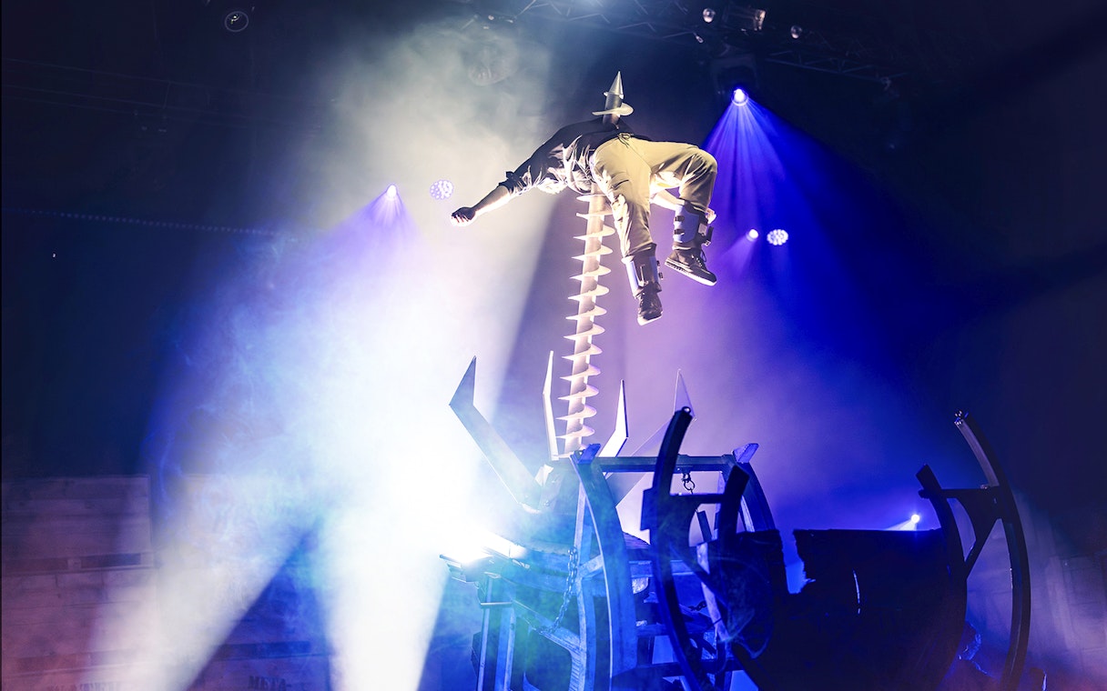 Performer suspended above a spiked wheel during Halloween event at Bobbejaanland.