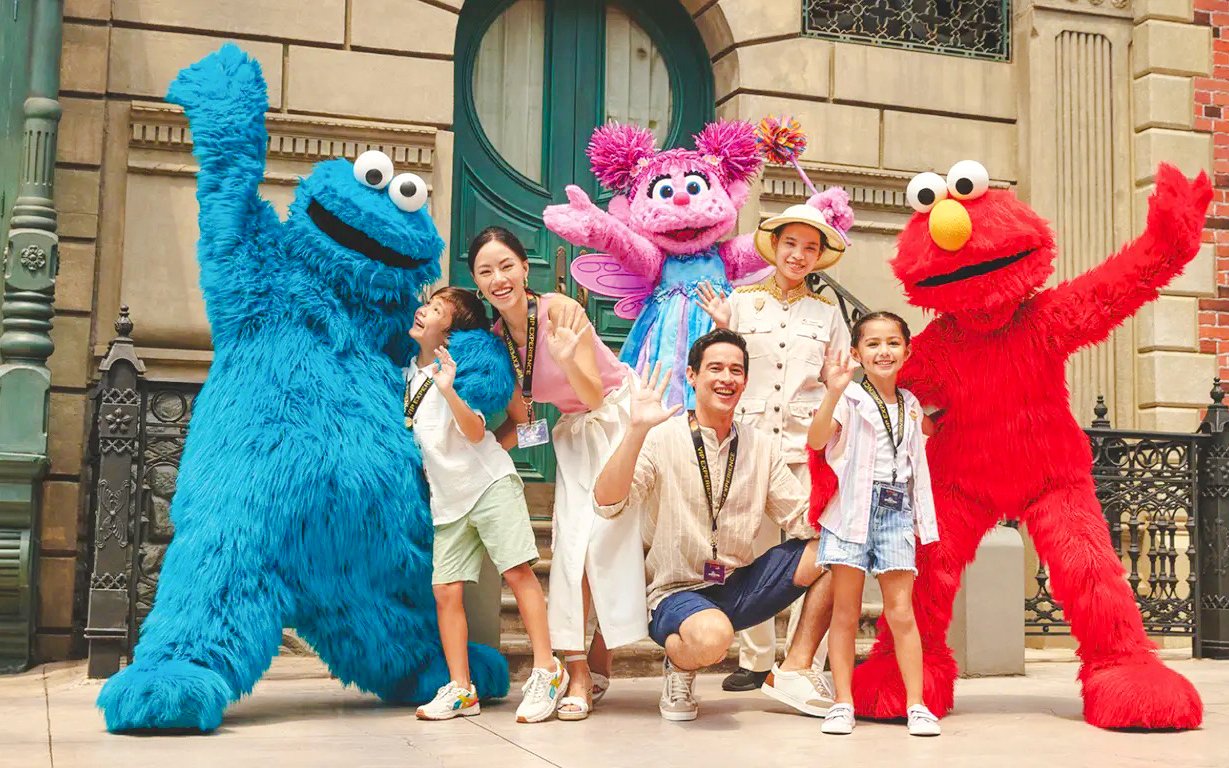 Visitors posing with Sesame Street characters at Universal Studios Singapore.