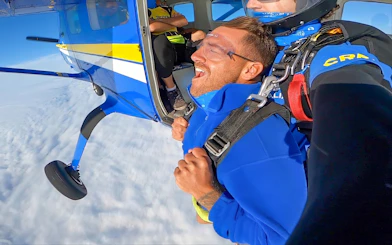 Tandem skydiving over Newcastle Beach, Sydney, with a view from the plane door.