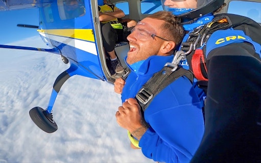 Tandem skydiving over Newcastle Beach, Sydney, with a view from the plane door.