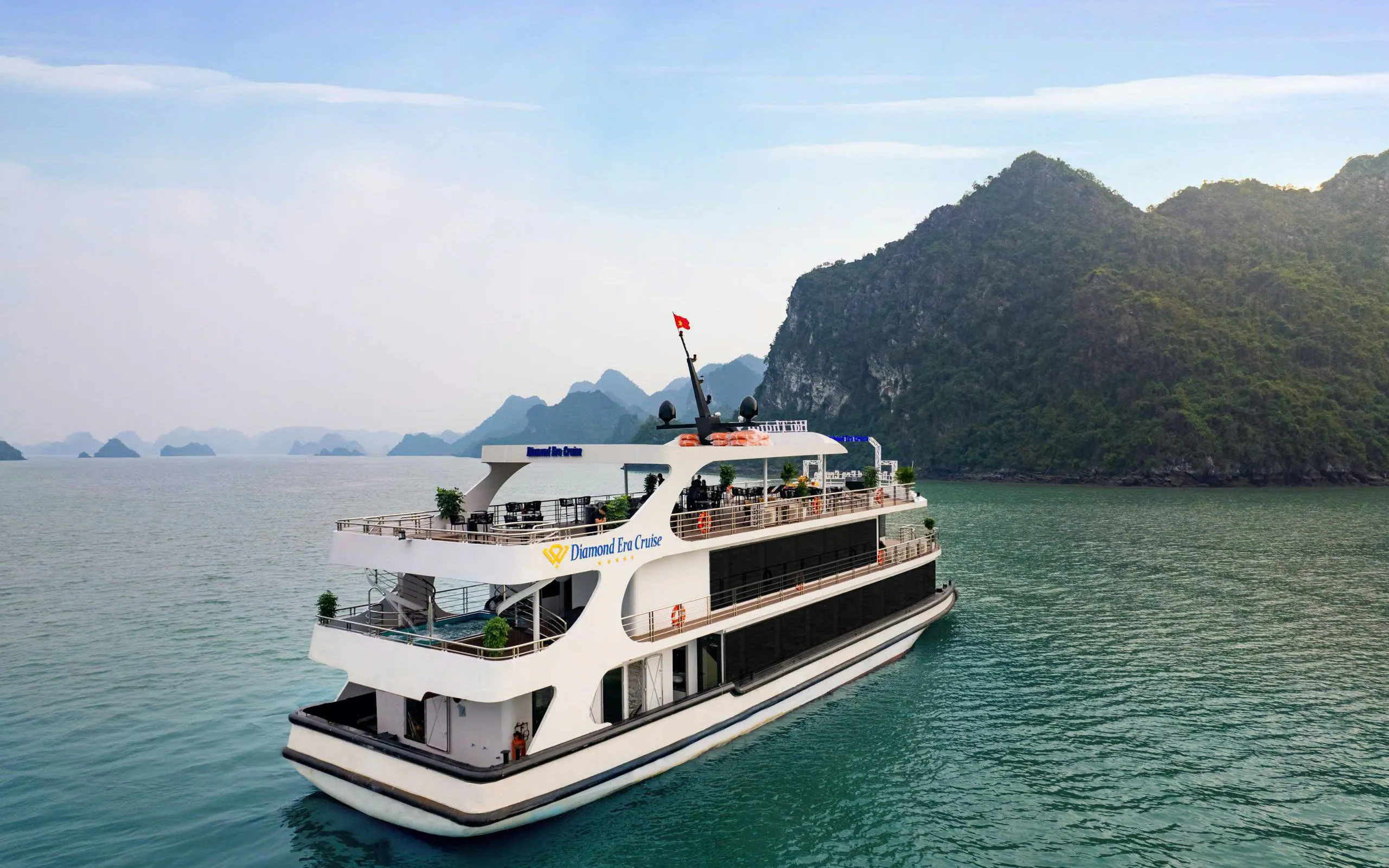 Luxury cruise ship in Ha Long Bay with limestone karsts in the background.