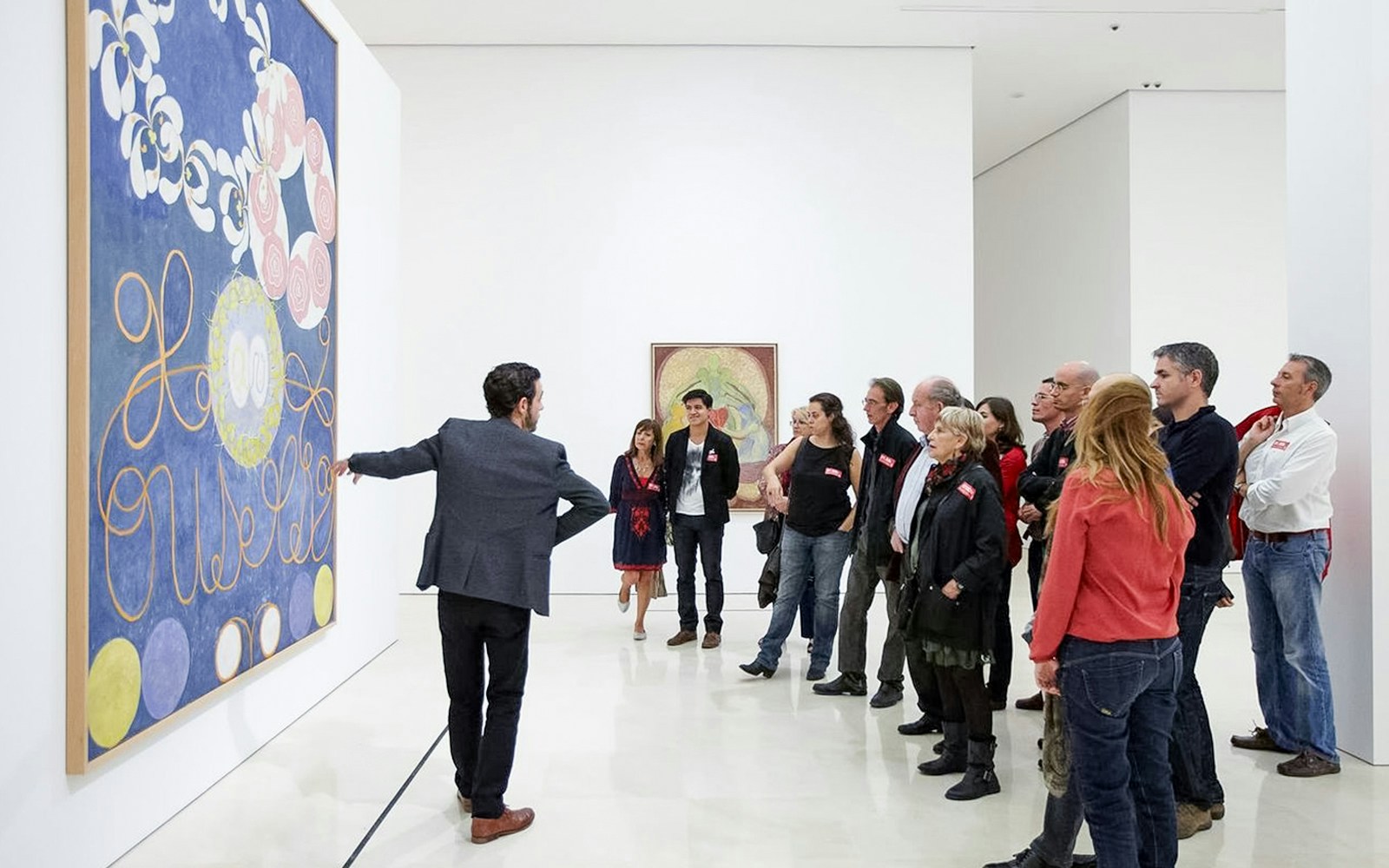 Visitors on a guided tour at Picasso Museum in Malaga, viewing artwork.