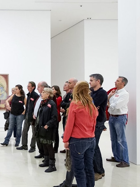 Visitors on a guided tour at Picasso Museum in Malaga, viewing artwork.