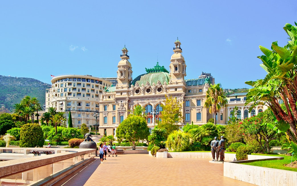 Monte Carlo Casino exterior with gardens and sculptures in Monaco.