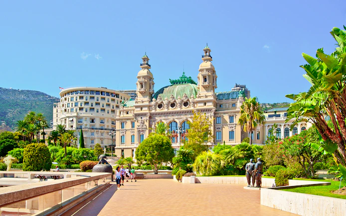 Monte Carlo Casino exterior with gardens and sculptures in Monaco.