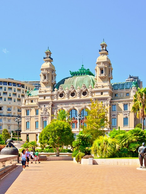Monte Carlo Casino exterior with gardens and sculptures in Monaco.