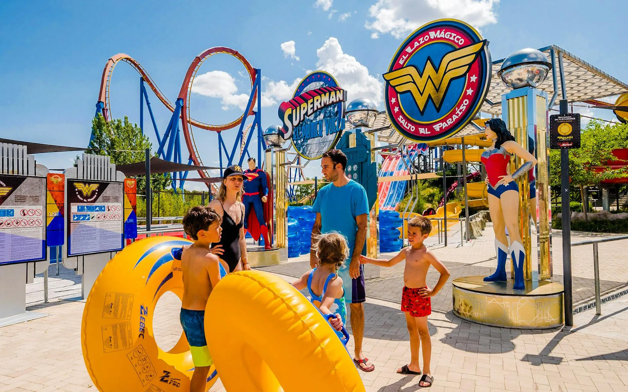 Family at Parque Warner Beach with Superman and Wonder Woman statues.