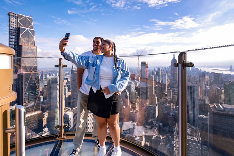 Visitors enjoying panoramic views of New York City from the Top of the Rock Observation Deck.
