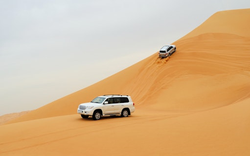 SUVs driving on sand dunes during a desert safari in Dubai.