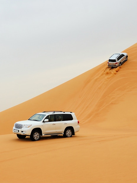 SUVs driving on sand dunes during a desert safari in Dubai.