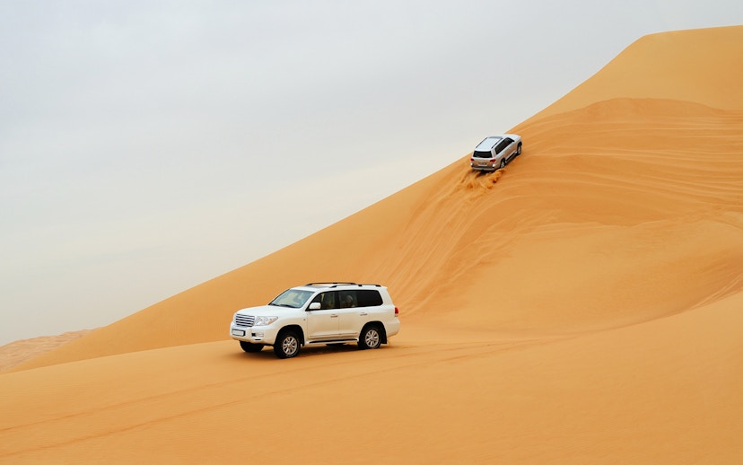 SUVs driving on sand dunes during a desert safari in Dubai.