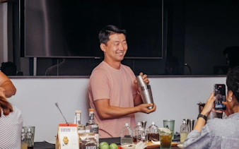 Man demonstrating cocktail shaking at a Vietnamese coffee-themed mixology class.