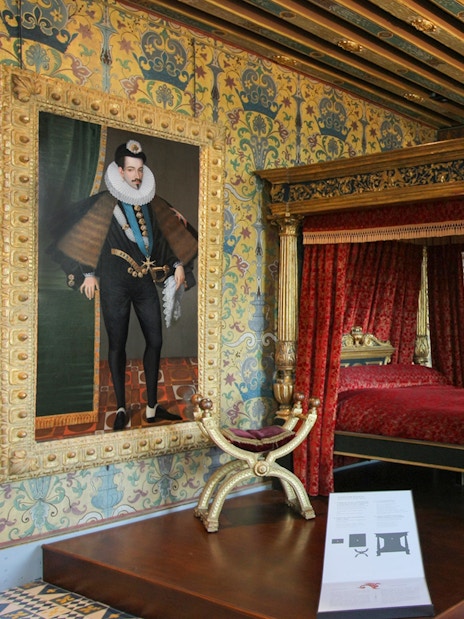 Royal Blois Castle bedroom with ornate canopy bed and historical portrait.
