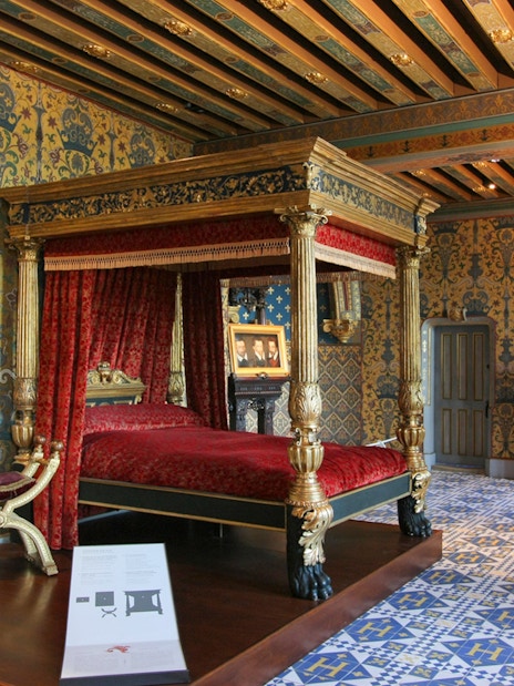 Royal Blois Castle bedroom with ornate canopy bed and historical portrait.