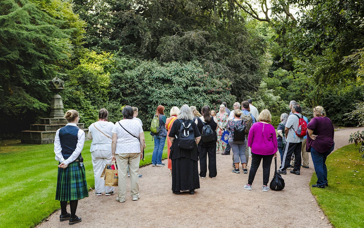 Group of tourists on a guided tour in the gardens of Palace of Holyroodhouse.