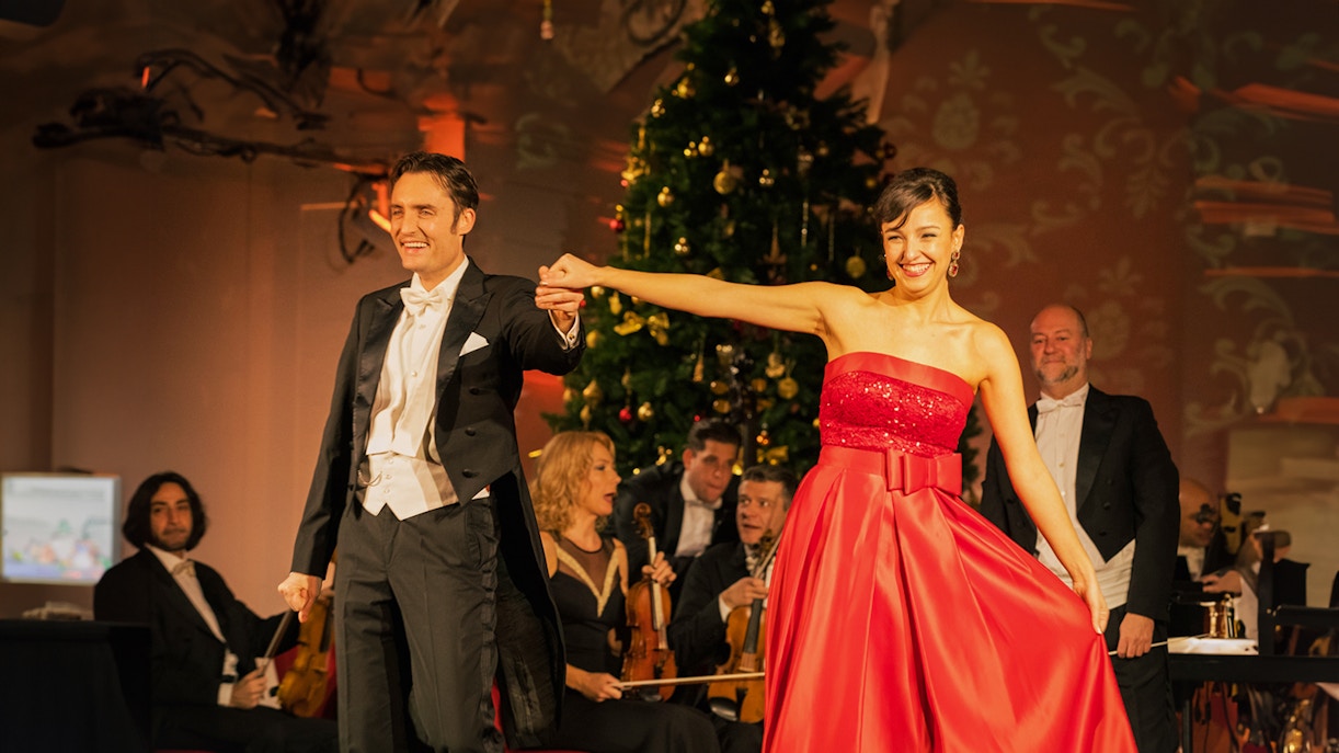 Performers at Schonbrunn Palace Concert with orchestra and festive decor.
