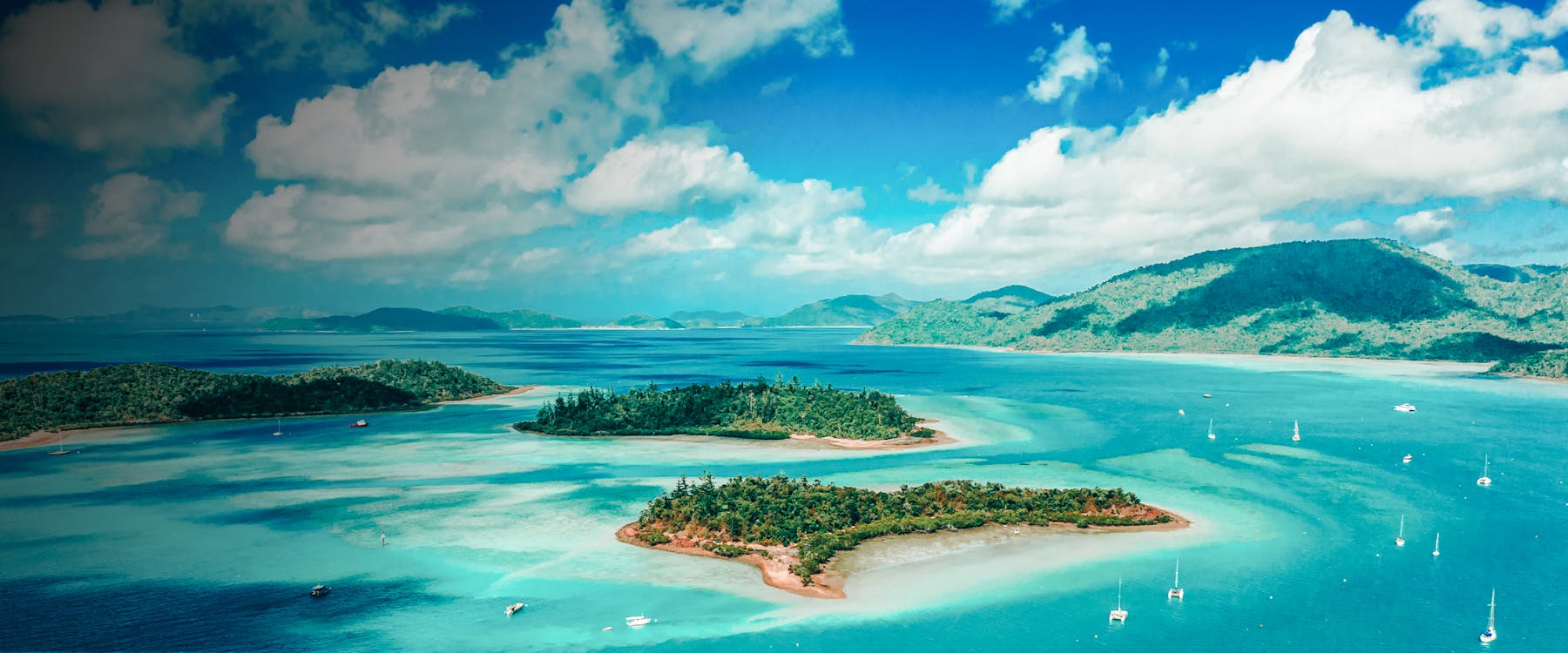 Aerial view of islands and turquoise waters in the Whitsundays, Australia.