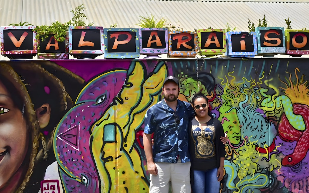 Tourists in front of colorful graffiti wall in Valparaíso, Chile.