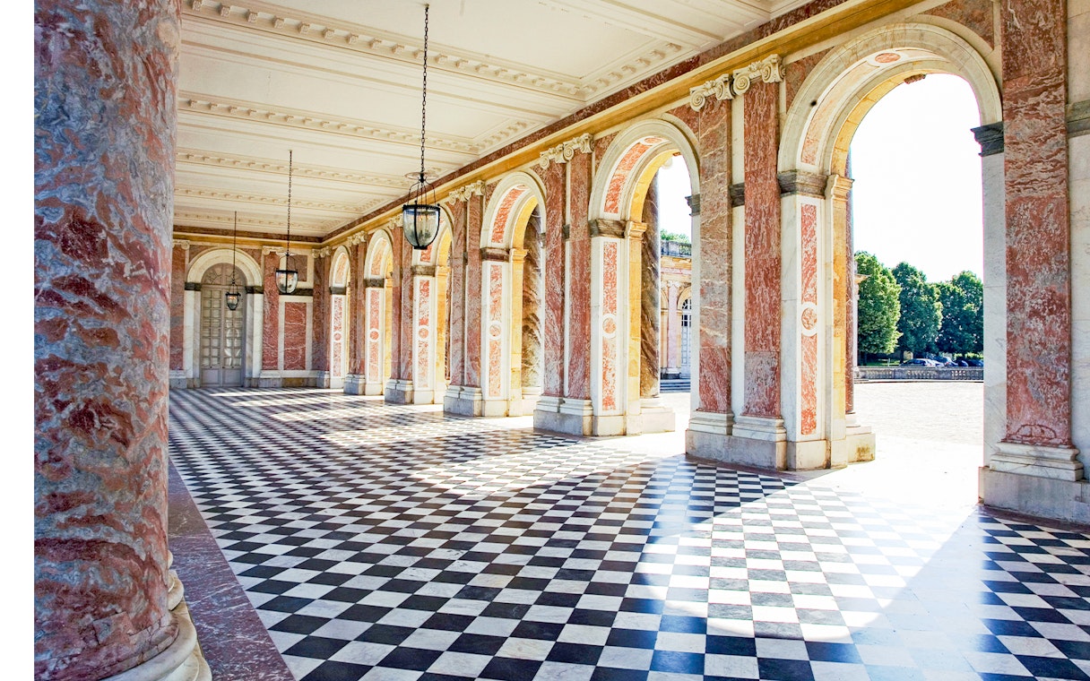 Grand Trianon colonnade with checkered floor in Versailles, France.