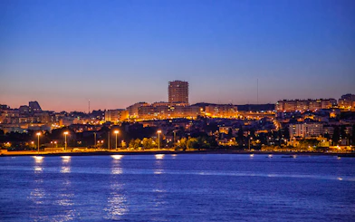 Lisbon cityscape at dusk viewed from a night cruise on the Tagus River.