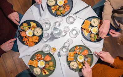 Dinner setting on Aurora Boreal cruise with plates of salmon, potatoes, and bread.