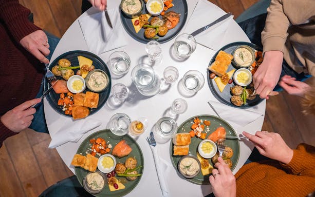Dinner setting on Aurora Boreal cruise with plates of salmon, potatoes, and bread.