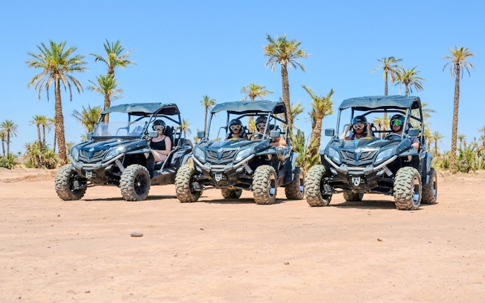 Quad bikes in the Palmeraie desert landscape during sunset tour.