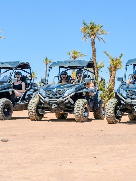 Quad bikes in the Palmeraie desert landscape during sunset tour.