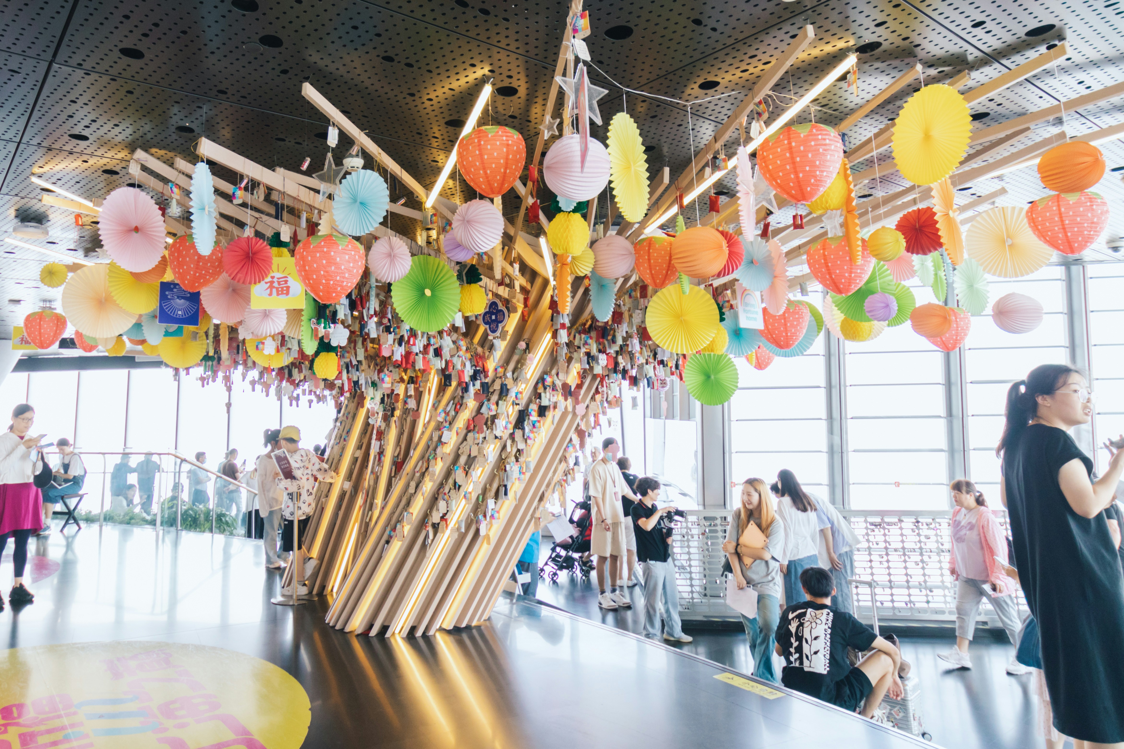 Colorful paper lanterns and decorations inside Shanghai Tower observation deck.