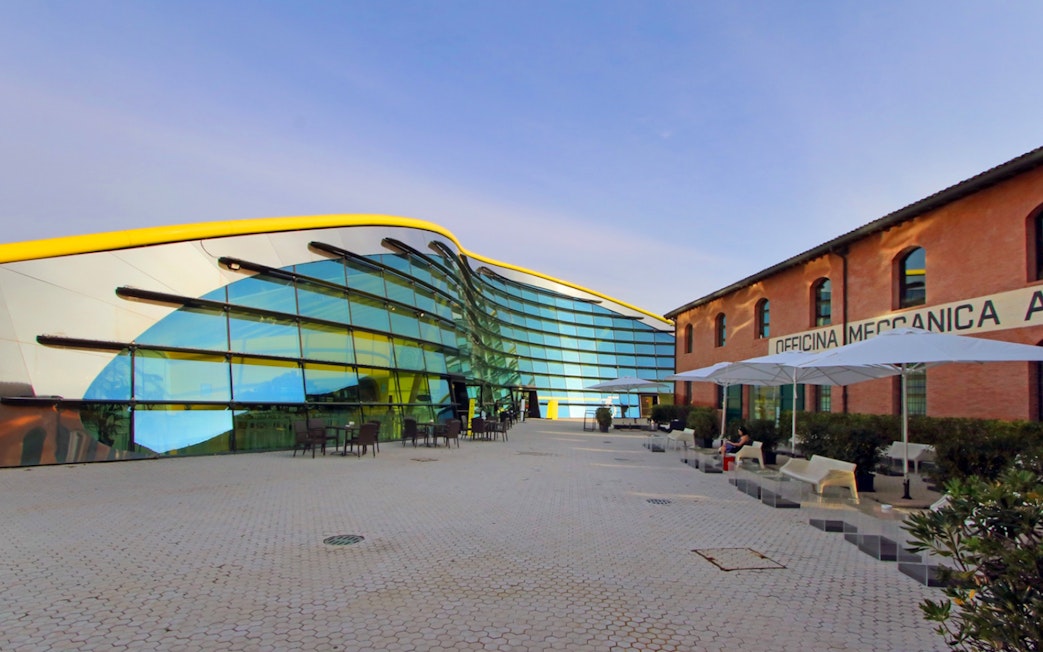 Enzo Ferrari House Museum with modern glass facade and historic brick building in Modena, Italy.