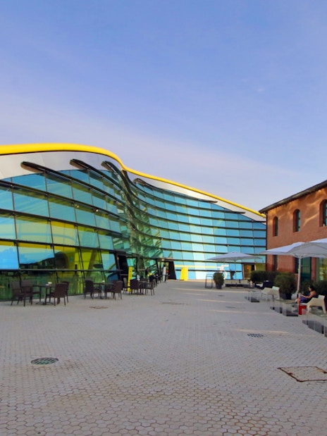 Enzo Ferrari House Museum with modern glass facade and historic brick building in Modena, Italy.