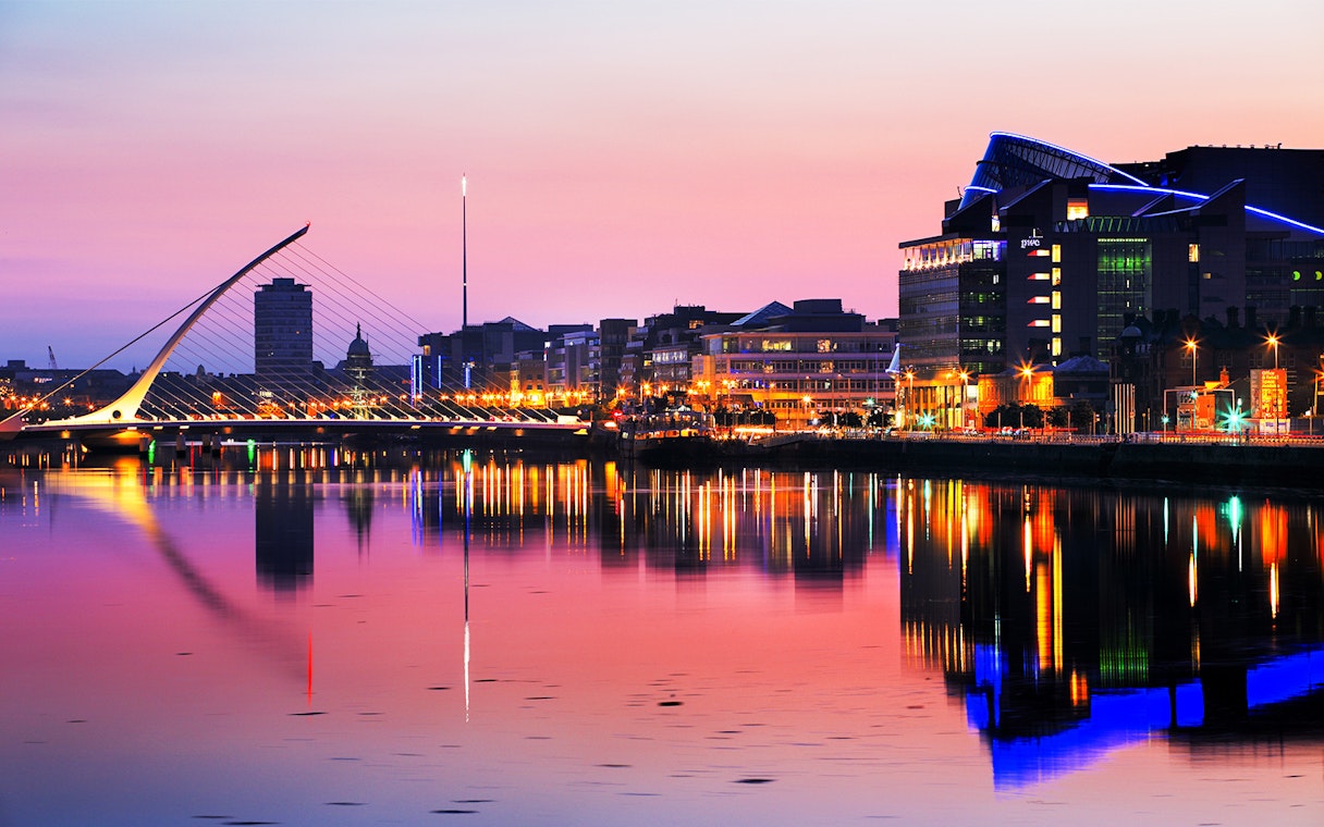 Samuel Beckett Bridge and Dublin skyline at sunset, reflecting on the River Liffey.