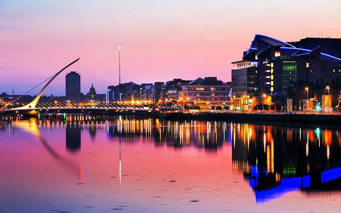 Samuel Beckett Bridge and Dublin skyline at sunset, reflecting on the River Liffey.