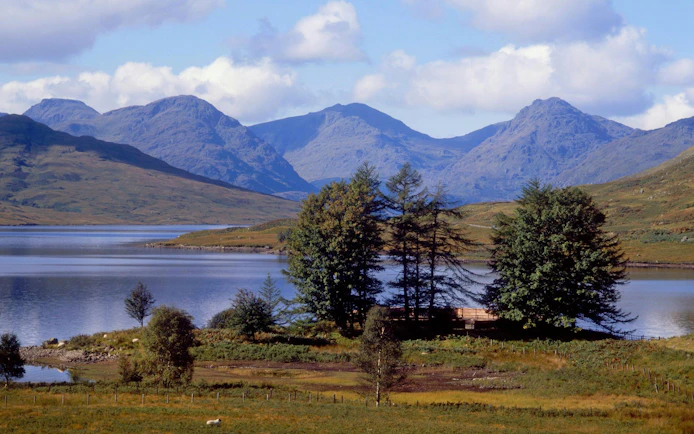 Loch Ness with surrounding hills and trees in the Scottish Highlands.