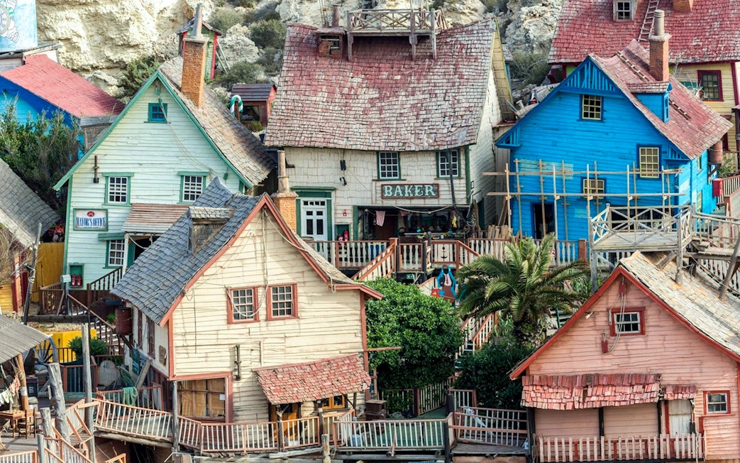 Colorful wooden buildings at Popeye Village, Malta, showcasing the unique architecture of the film set.