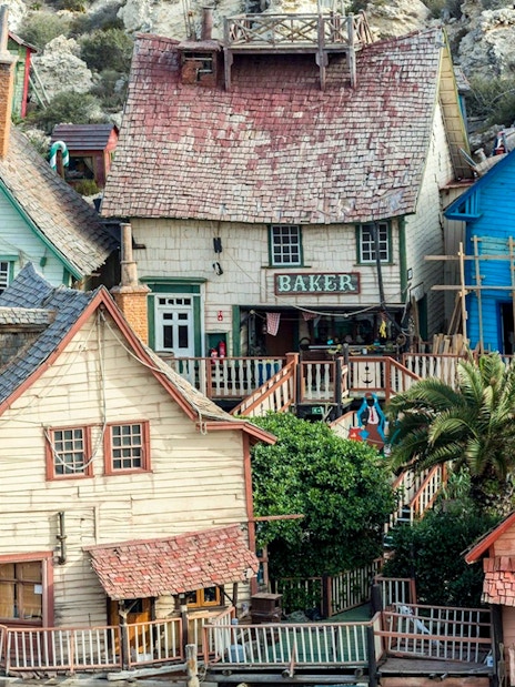 Colorful wooden buildings at Popeye Village, Malta, showcasing the unique architecture of the film set.