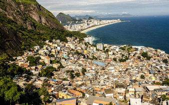 Aerial view of Vidigal favela with Rio de Janeiro coastline and ocean in the background.