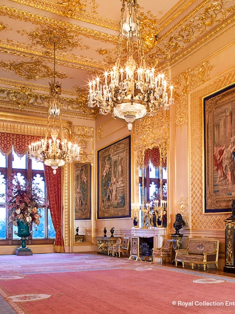Windsor Castle interior with ornate chandeliers, tapestries, and gilded decor.