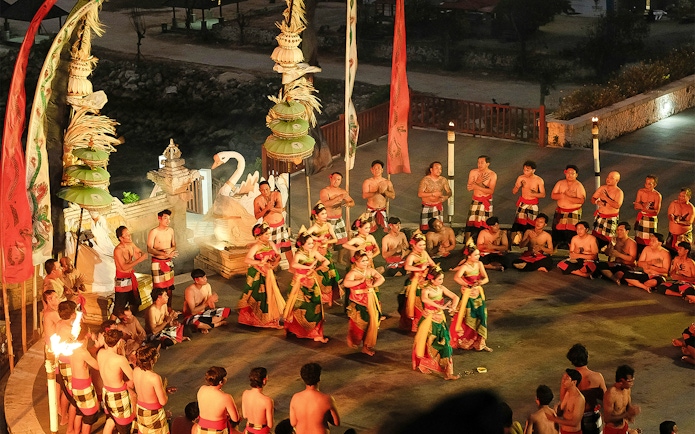 Kecak and Fire Dance performance by the beach in Bali, featuring traditional costumes and chanting circle.
